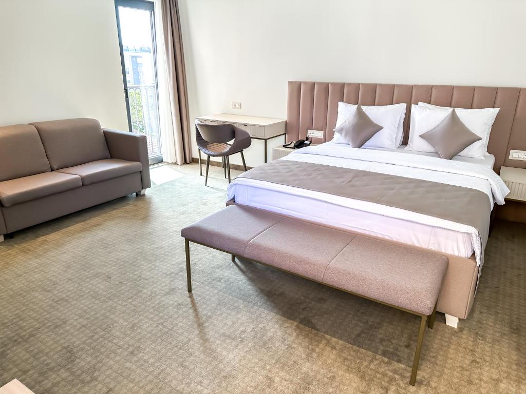 布德瓦Hotel Pima Budva的一间卧室配有一张大床和一张沙发