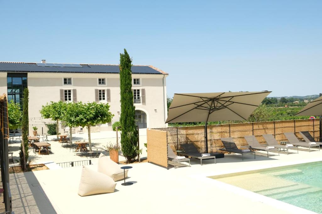 德龙河畔利夫龙Garenne的一个带游泳池、椅子和遮阳伞的庭院