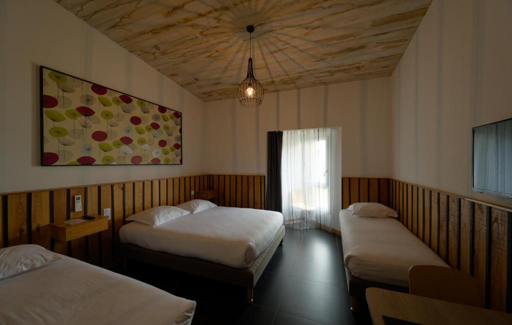 查姆布里陶德Cit'Hotel Le Relais du Boisniard的酒店客房设有两张床和窗户。