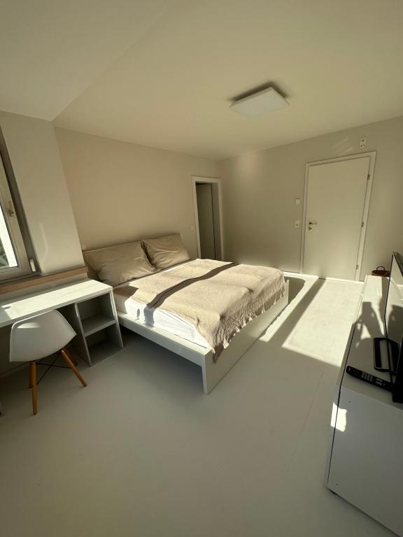 NiederalmCasa Móre BEIGE的白色卧室配有床和书桌