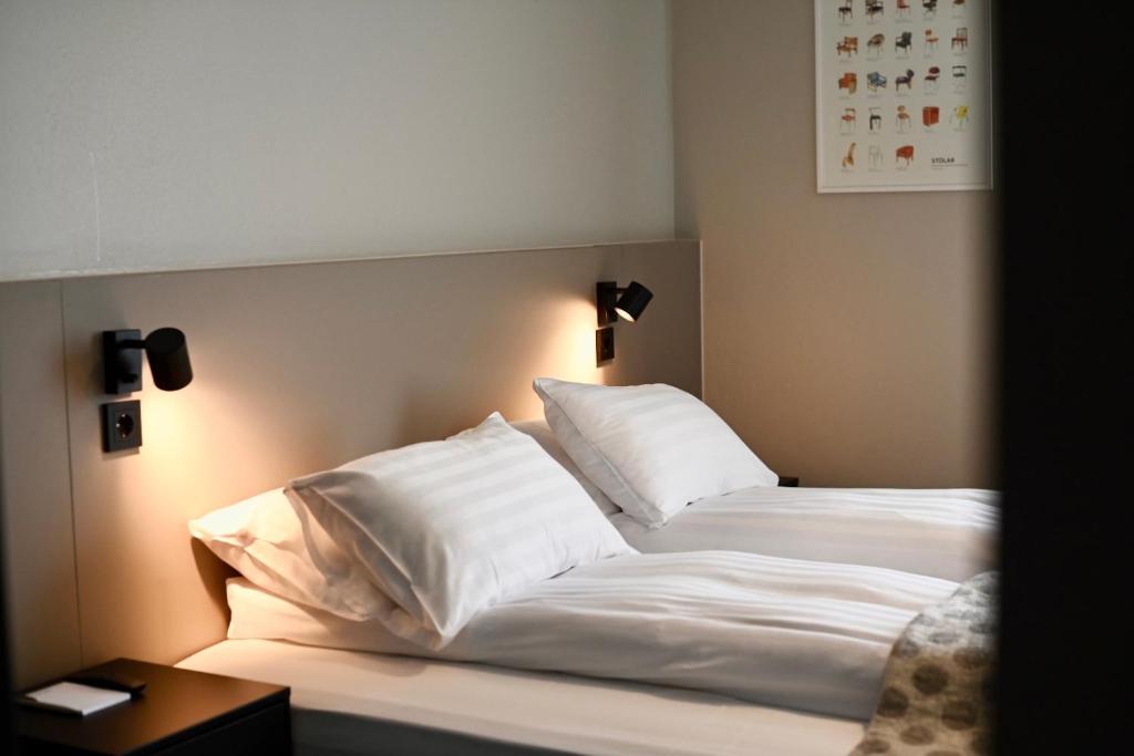 雷克雅未克Hotel Local 101的一间卧室配有带白色床单和枕头的床。