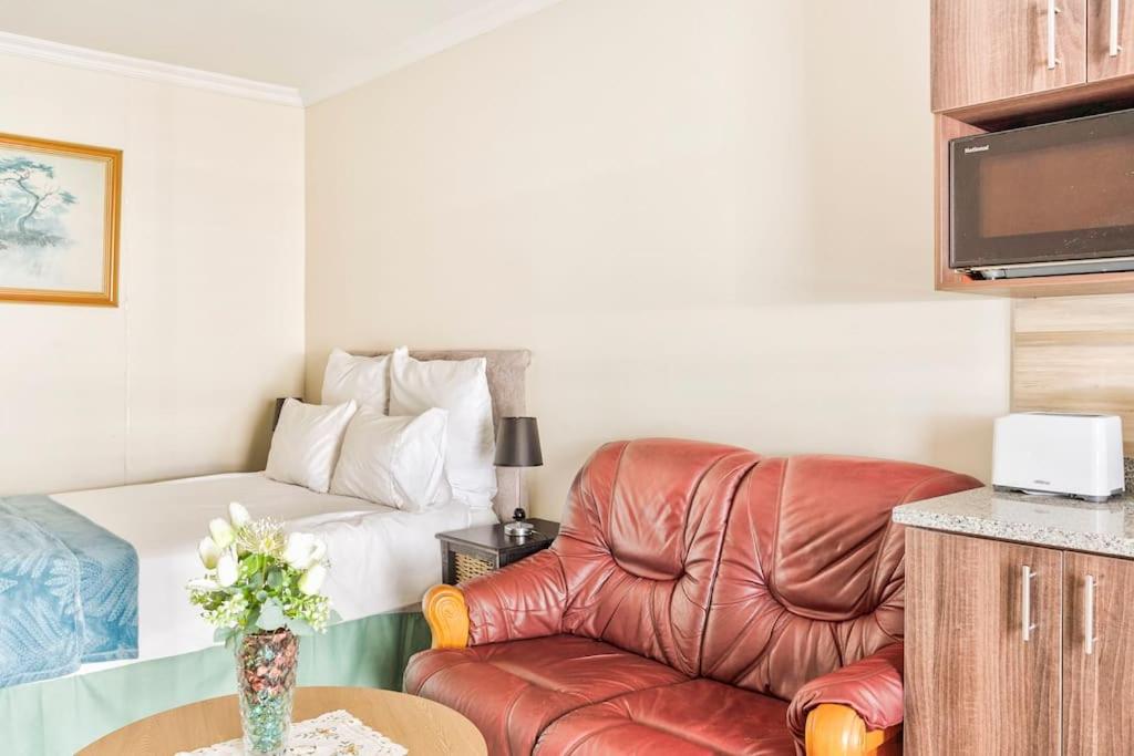 开普敦Goodwood Oasis Free WiFi-Parking 2的客厅配有真皮座椅和床