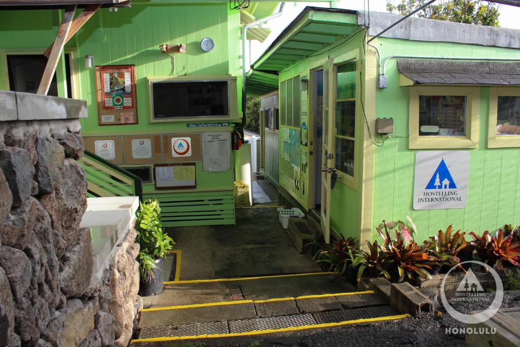 檀香山Hostel Honolulu的绿色建筑的入口,有门