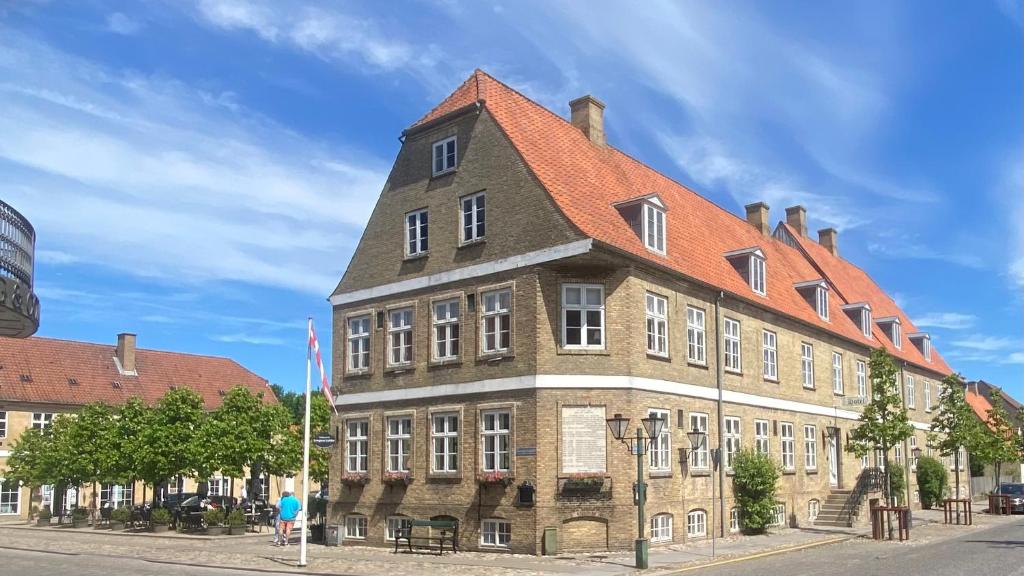 克里斯蒂安斯费尔德伯劳德蒙格赫登斯酒店的一座大型砖砌建筑,屋顶橙色