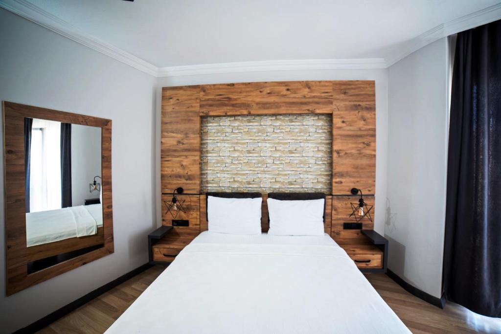 格克切达镇İmroz Adali's Butik Otel的一间卧室配有一张大床和镜子