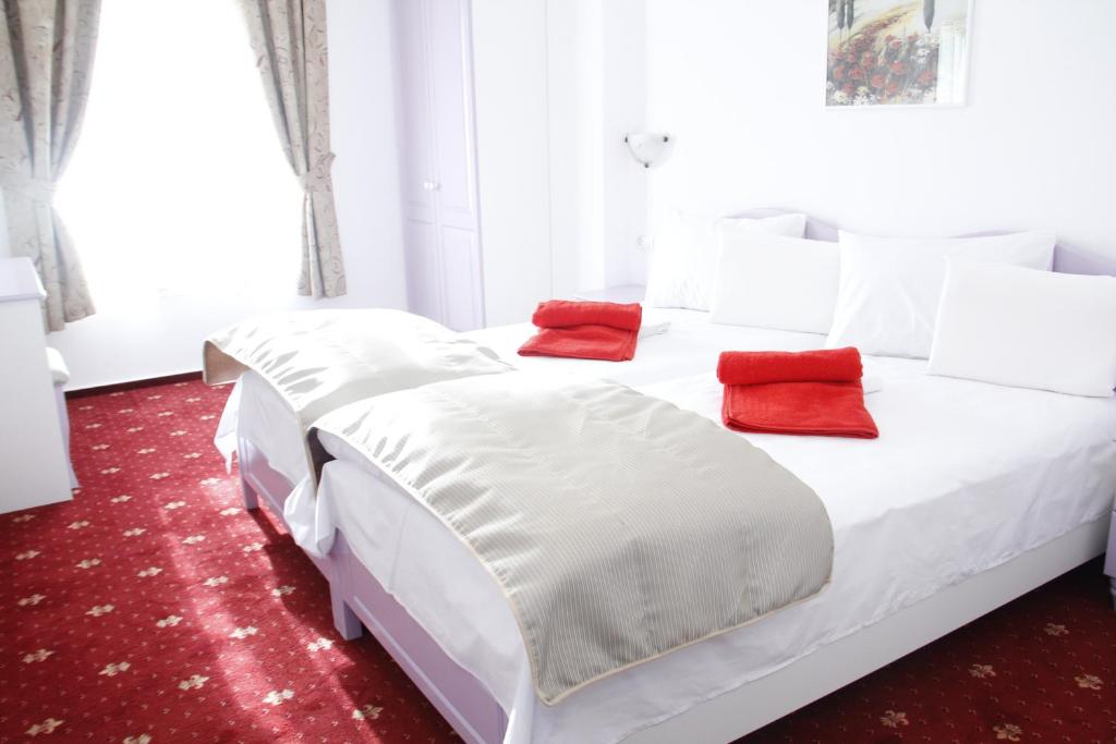 蒂米什瓦拉Hotel Exclusiv的一张带两个红色枕头的白色床