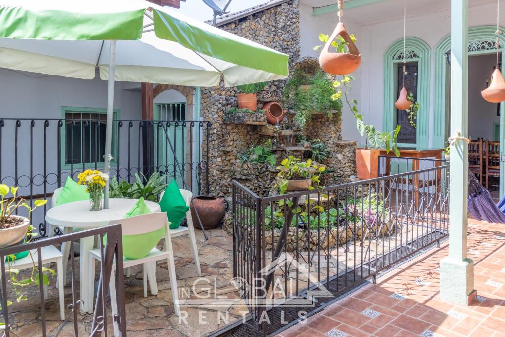 卡利Sandalio Hostal Cali的一个带桌子和遮阳伞的庭院
