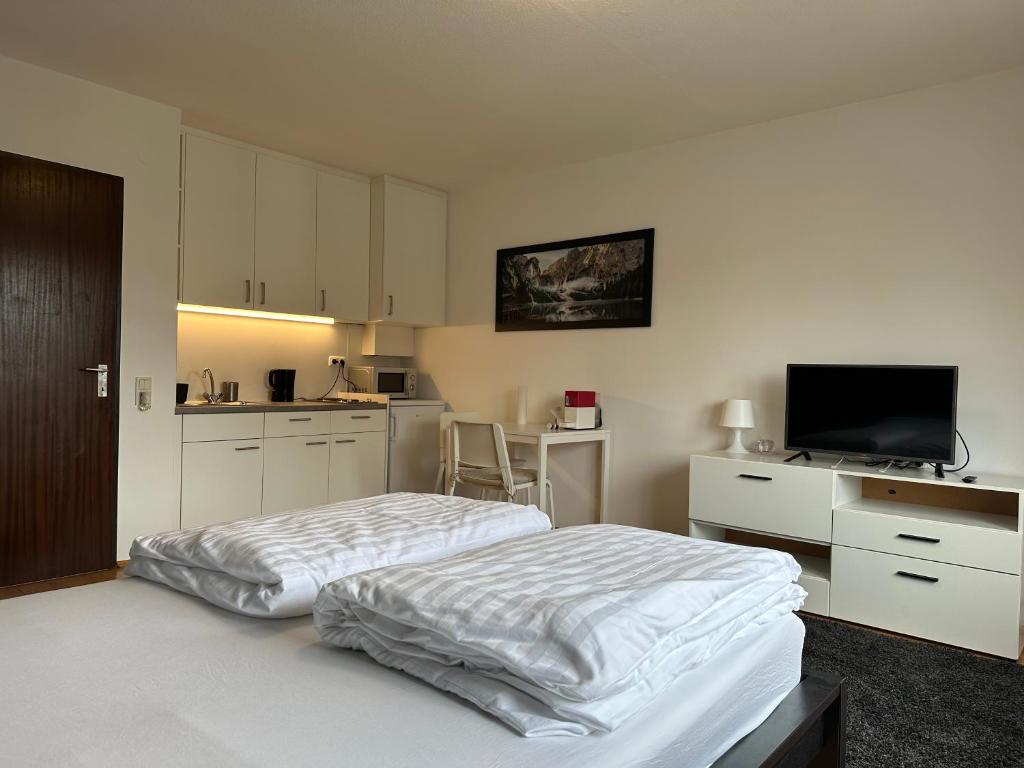 林茨Studio Apartment near Linz Main Train Station的一间白色卧室,配有床和厨房