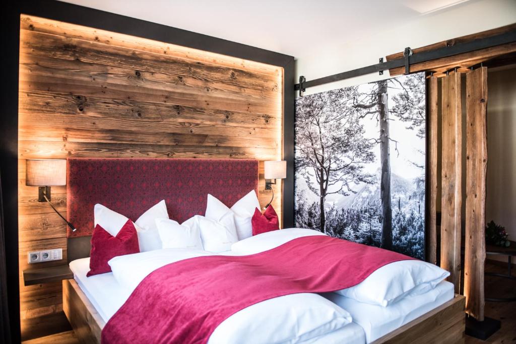 鲁波尔丁苏尔波斯特酒店的一间卧室配有一张带红色和白色枕头的大床