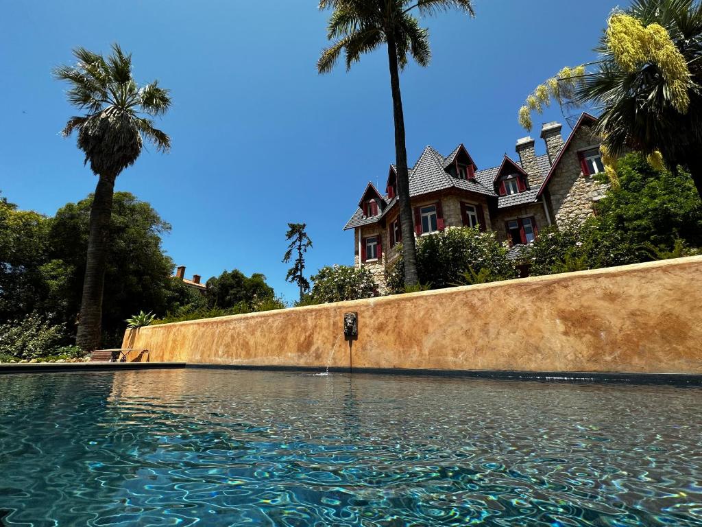 卡斯卡伊斯Chalet Ficalho的游泳池前棕榈树的房子