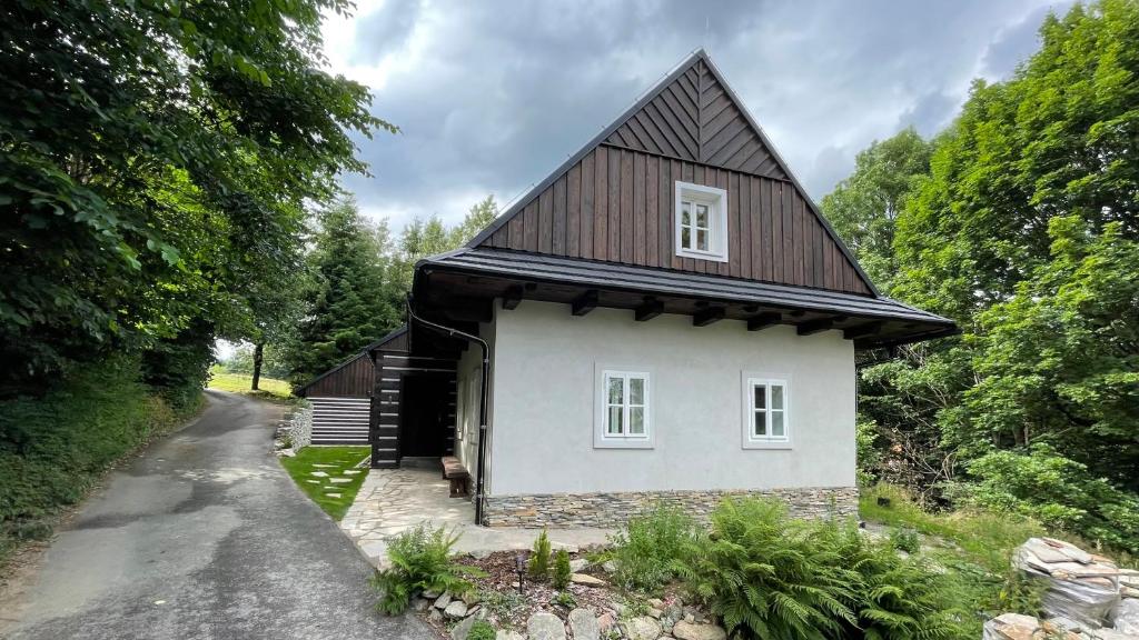 Horní HeřmaniceChalupa Horní Heřmanice的一间白色的小房子,有棕色的屋顶