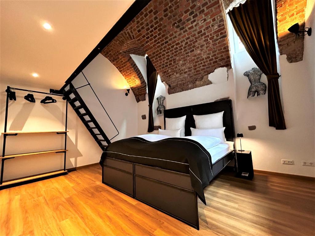 弗莱堡Historical Luxury Homes - Luxus Familien Suite的一间卧室设有一张大床和砖墙