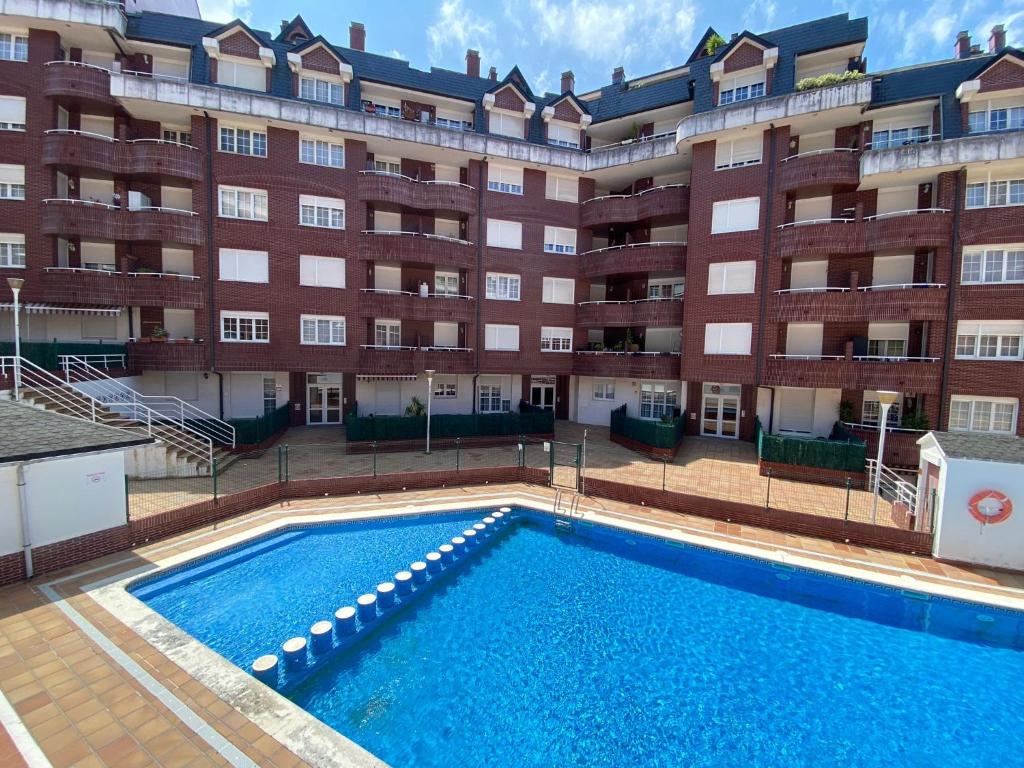 乌迪亚莱斯堡Paraíso Soleado: Piso con Terraza, Piscina y Garaje a 5 min de Playa的大楼前的游泳池