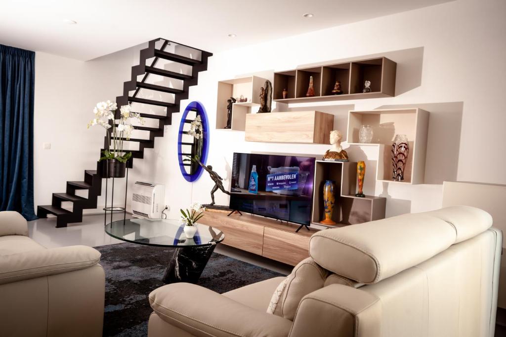 安特卫普Suite Aux Anges的一间带电视和楼梯的客厅