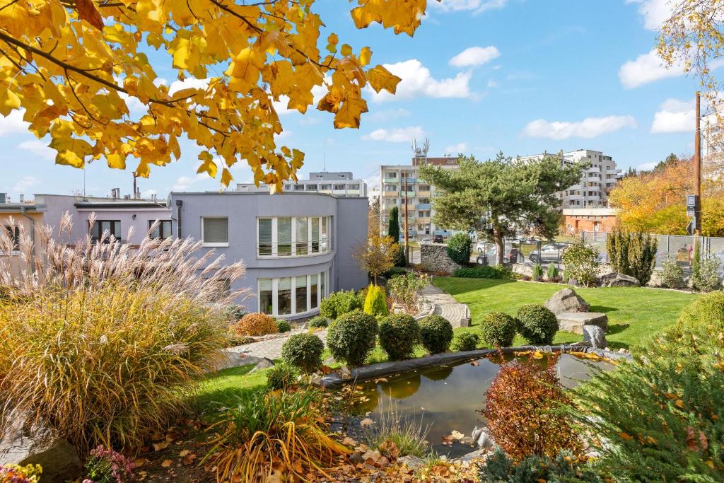 布拉迪斯拉发Large private apartment with garden view, terrace and free parking的一座花园,在一座建筑前设有一个池塘