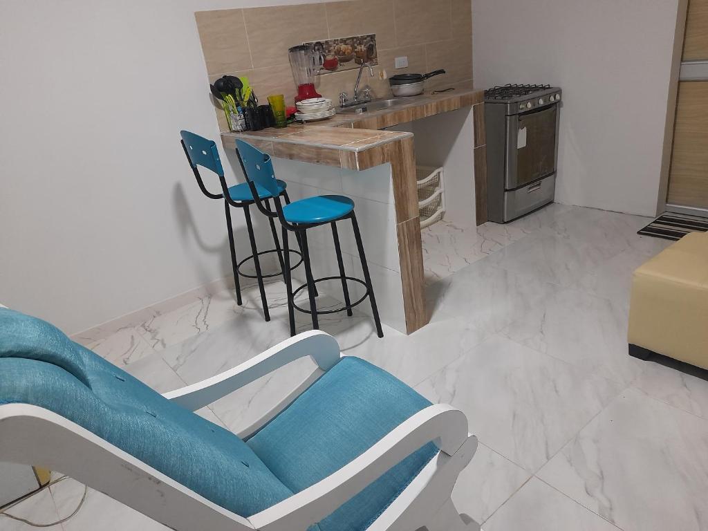 里奥阿查APARTA ESTUDIO PERLA ROJA的一间带蓝椅的客厅和一间厨房