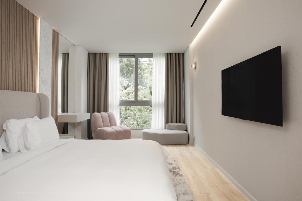 雅典Nur Aparthotel Athens的白色的酒店客房 - 带床和平面电视