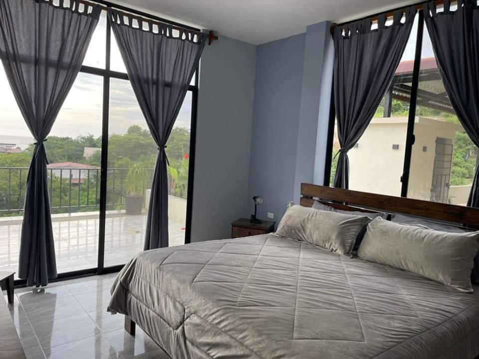 洛佩斯港Departamento vista al mar Puerto López的一间卧室设有一张大床和一个大窗户