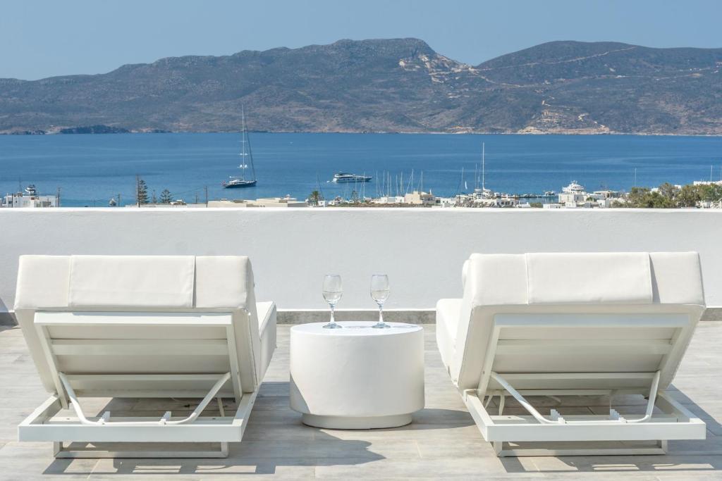 阿达玛斯CASA ANNA LOFT Boutique House with Full Sea View的两把白色椅子和一张带酒杯的桌子