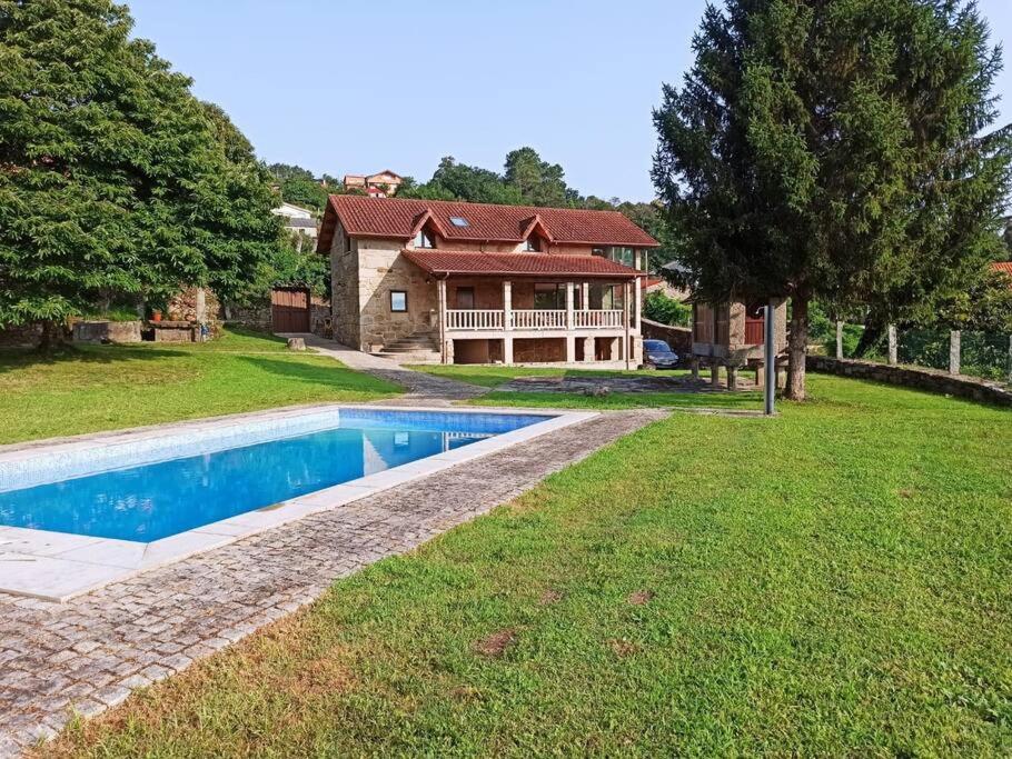 Casa rural con piscina的庭院中带游泳池的房子
