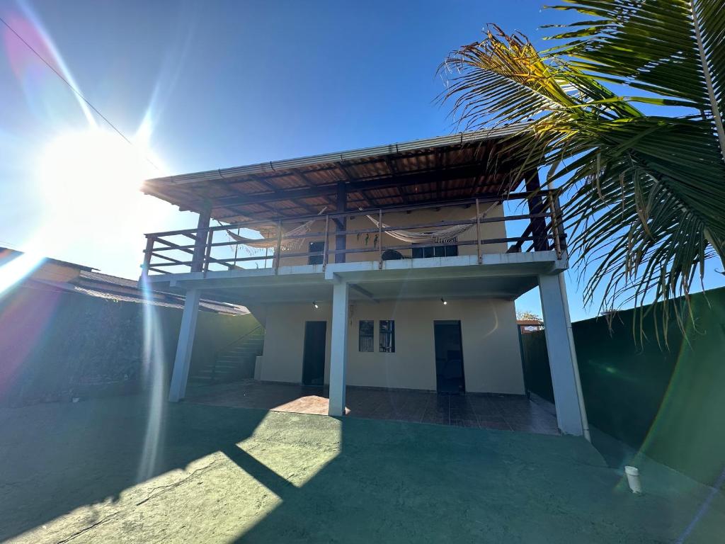 戈亚斯州上帕莱索Flats Paraíso Dos Ipês的带阳台和棕榈树的房子