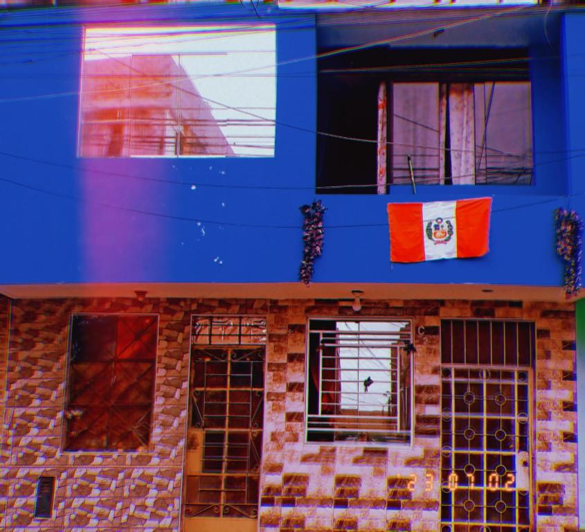 利马Inti Hostel Airport的上面有旗帜的蓝色建筑