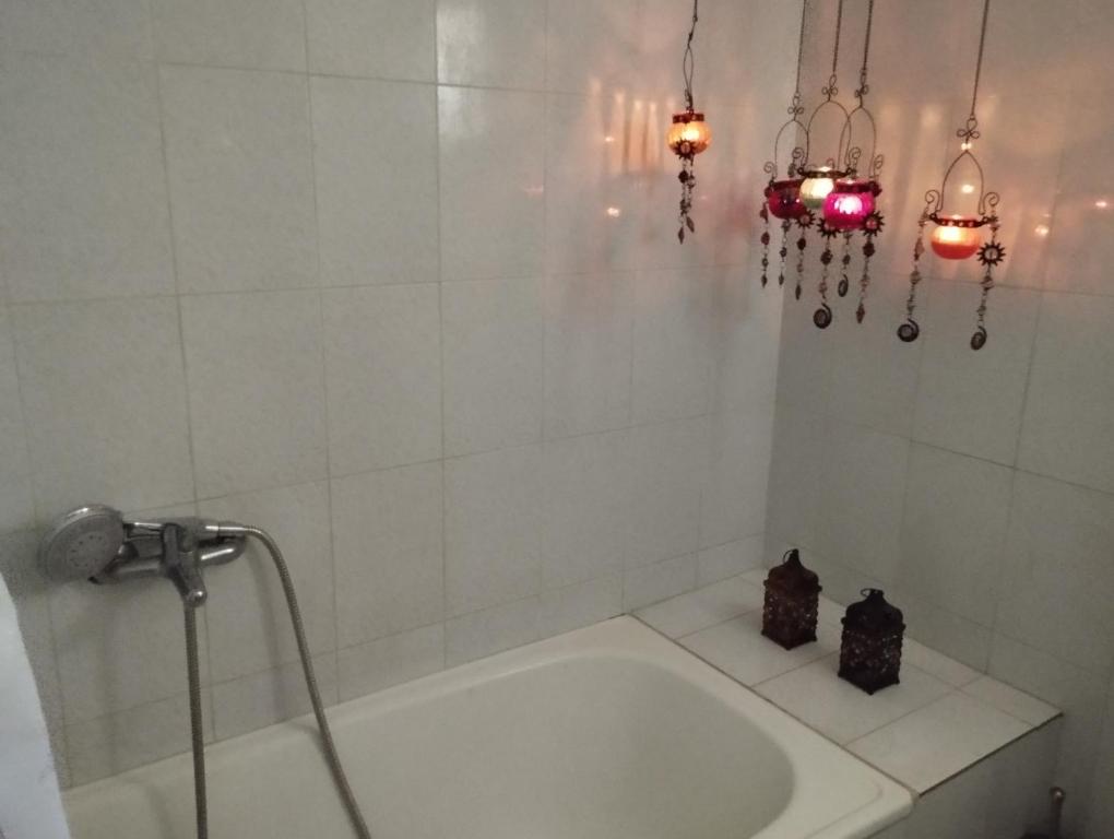 VergiaAmadrias by the sea的白色的浴室设有浴缸和吊灯。