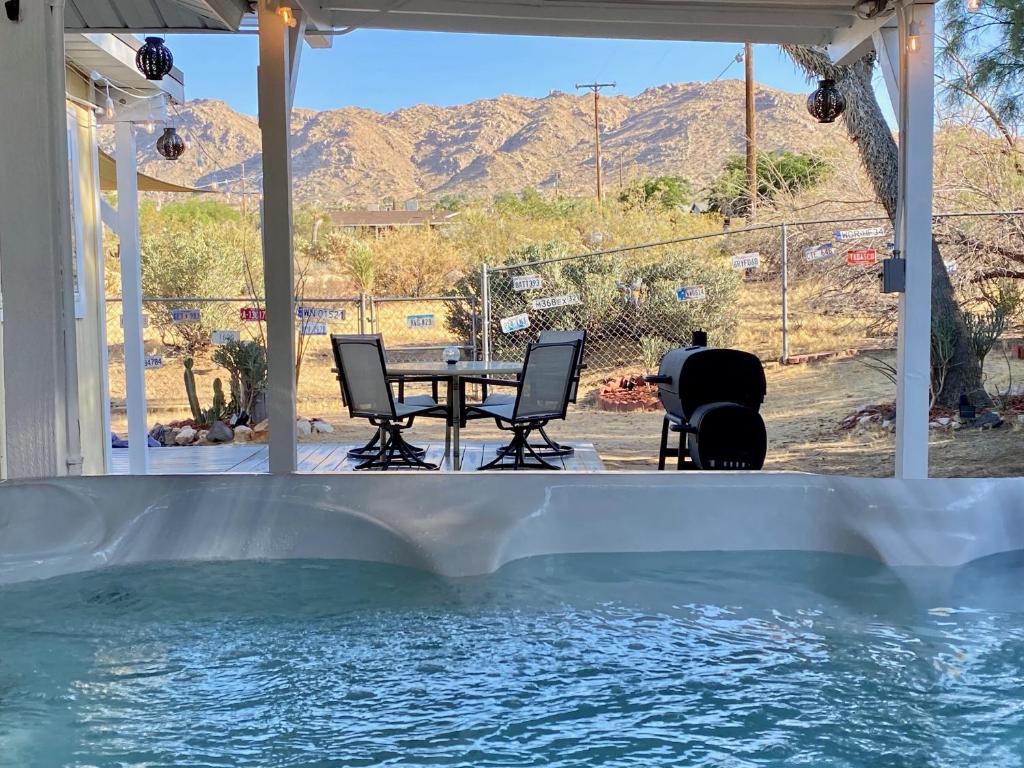约书亚树Float Pool, Hot Tub, Sauna, Firepit, BBQ, Telescope, Views, EV Chg,的一个带桌椅的庭院和一个游泳池