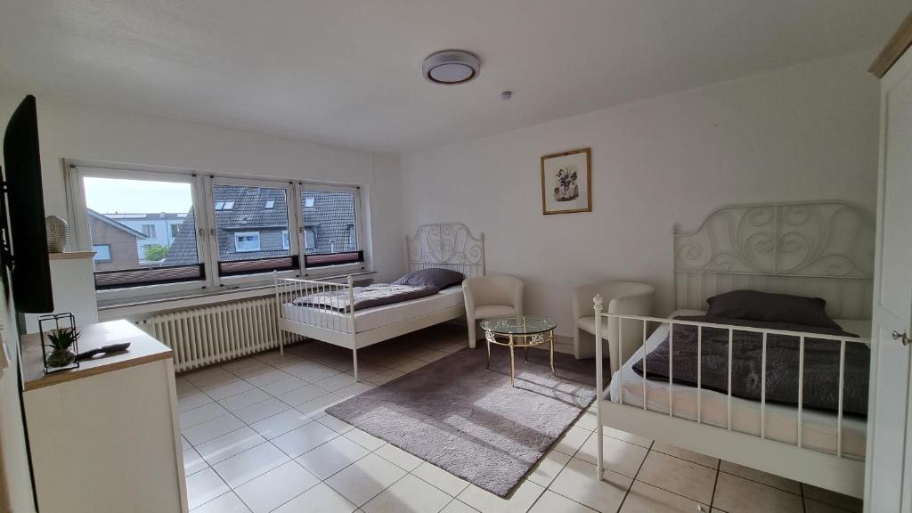 博霍尔特Bocholt Apartment Ferienwohnung的一间卧室设有两张床、一张桌子和一个窗口