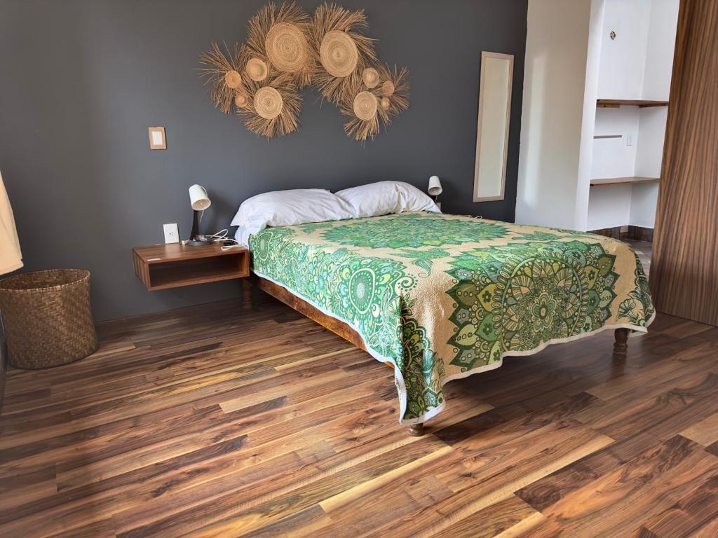 帕茨库卡罗Casa San Pancho Centro Mágico的一间卧室配有一张床,铺有木地板