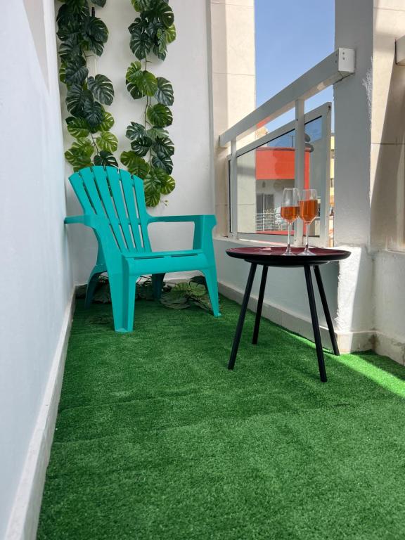 RufisqueThe coolest room的阳台配有桌椅和绿色地毯。
