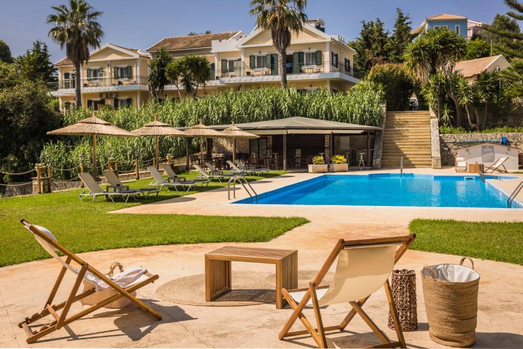斯巴达Theros Retreat的一个带游泳池和椅子的度假胜地和一座建筑