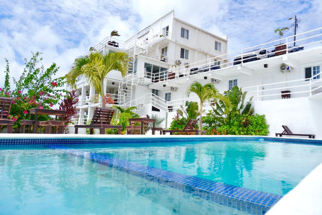 罗阿坦Ocean View Hotel and Restaurant的一座白色大建筑前的游泳池
