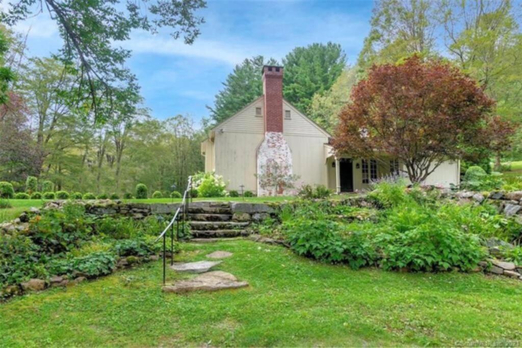 Cottage Retreat - Historic Cottage Home w Home Gym的一座古老的白色房子,在院子里设有一个花园