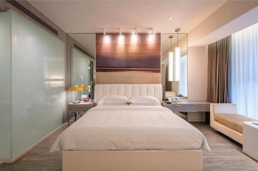 杭州锦江都城杭州市火车东站酒店的卧室配有一张白色大床和一张书桌