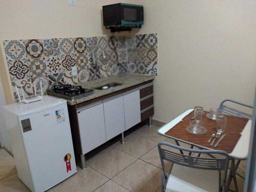 尼泰罗伊Loft Aconchegante no Centro de Niterói!!的小厨房配有小桌子和冰箱