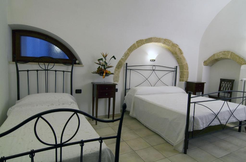 帕拉比塔B&b Altrov'è的一间卧室设有两张床和窗户。