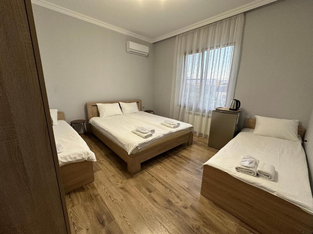 古达乌塔Narsou Guest House的客房设有两张床和窗户。