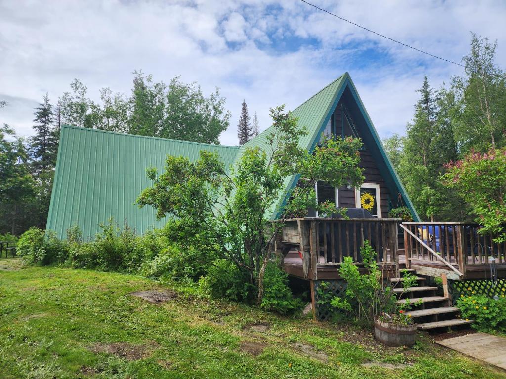 索尔多特纳A-frame cabin between Kenai and Kasilof rivers的绿色屋顶和甲板的房子