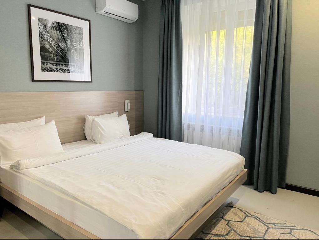 阿拉木图Resident Hotel Gogol的卧室配有一张大白色床和窗户