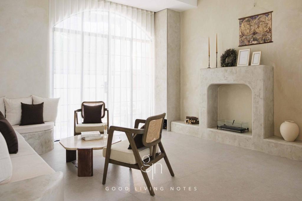高雄瀉湖-私人公寓 The Lagoon-Mediterranean vibe vacation house的客厅配有椅子和壁炉
