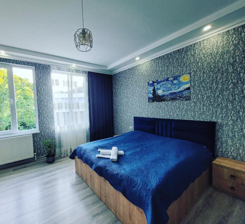 博尔若米White House In Borjomi的一间卧室配有一张蓝色的床,上面有两个白色的十字架