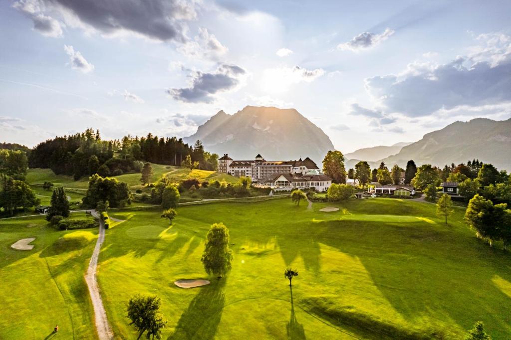 恩斯河谷艾根IMLAUER Hotel Schloss Pichlarn的享有高尔夫球场的景色,背景是山脉