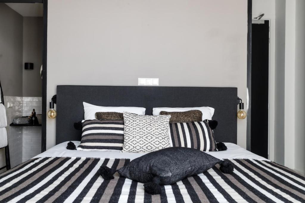 登博斯KASerne Boutique Hotel的一间卧室配有一张大床,提供黑白枕头