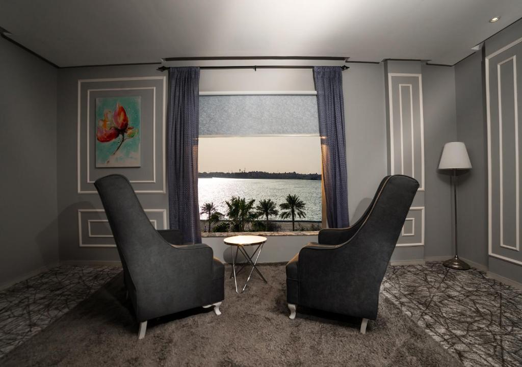 达曼阿尔科尼池金花园酒店的客厅配有两把椅子和窗户