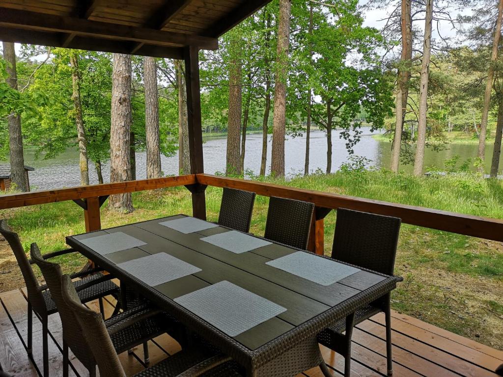 MostowoOsrodek Wypoczynkowy RAJ的湖景门廊上的桌椅