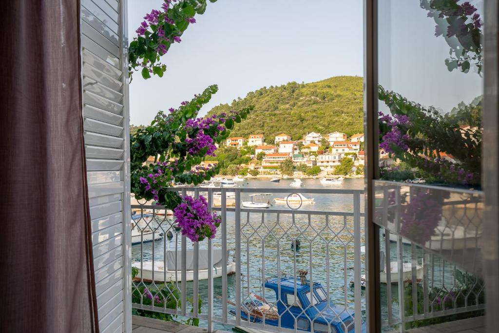 布尔纳Bugenvilija apartment的从带紫色鲜花的度假村阳台上可欣赏到风景