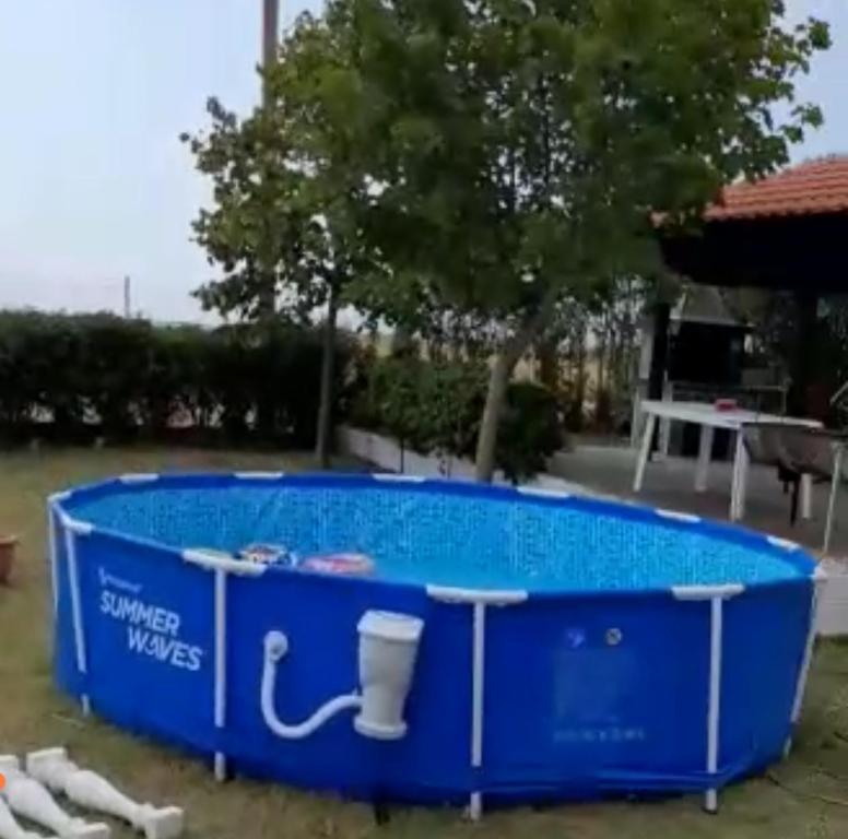 RodhókiposΕΝΟΙΚΙΑΖΟΜΕΝΟ ΔΩΜΑΤΙΟ ΜΕ ΘΕΑ ΣΤΗΝ ΕΞΟΧΗ的院子里的大型蓝色游泳池