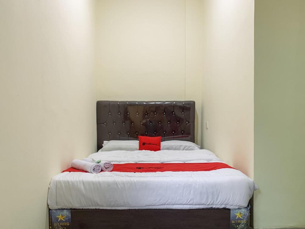 SagulungRedDoorz @ Cikitsu Batam的床上有红色枕头