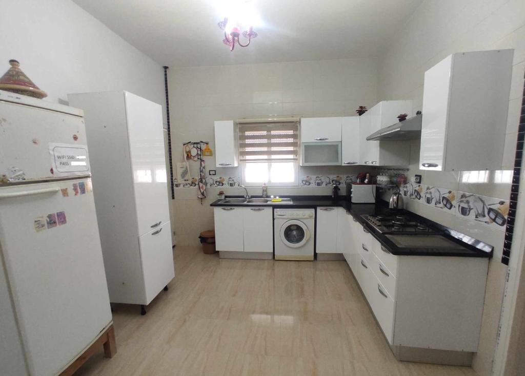 泰塔温Villa Mimosa Tataouine的厨房配有白色家电和白色橱柜